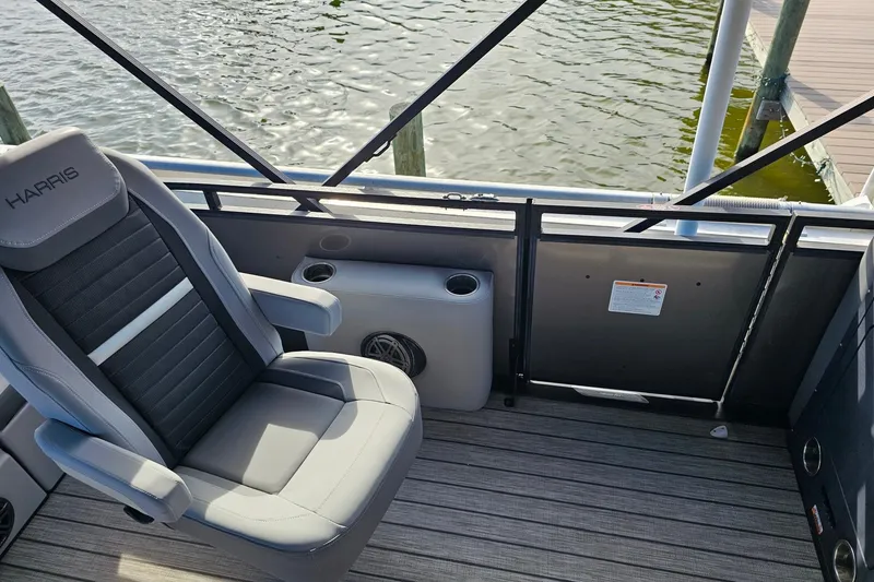 Slide: The Image of Luxury Harris boat seat with cup holder, 2024 model, docked by water. - 20