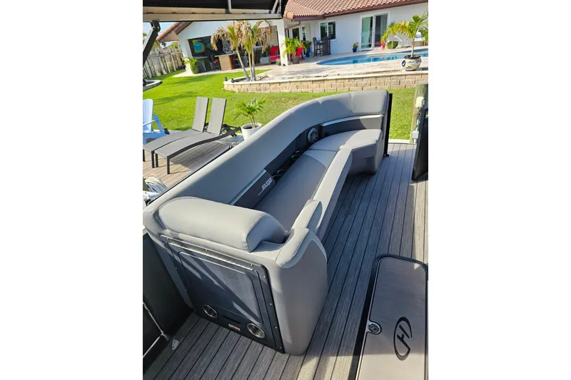 Slide: The Image of Luxurious 2024 Harris boat seating area with modern design, overlooking a poolside patio. - 22