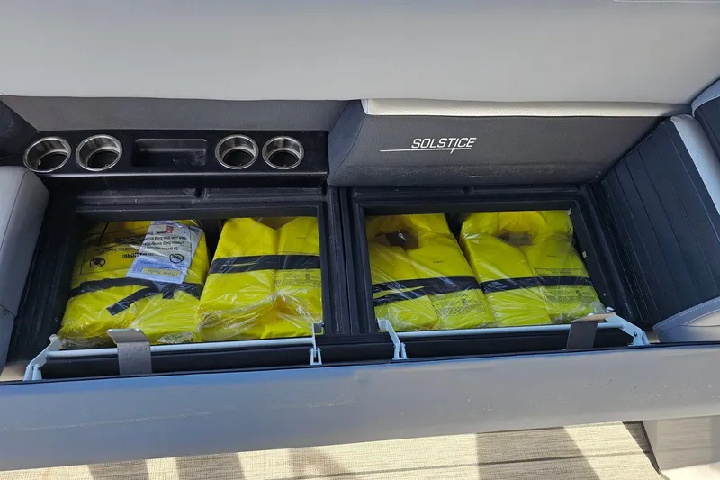Slide: The Image of Storage compartment in a 2024 Harris boat with yellow life jackets. - 25