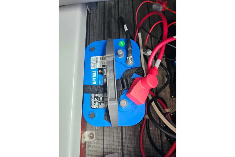 Slide: The Image of Blue Optima battery with red cables, secured in a 2024 Harris model setup. - 26