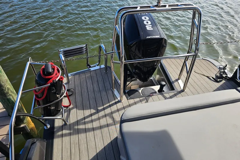 Slide: The Image of 2024 Harris boat deck with Mercury 300 engine, docked by water. - 27