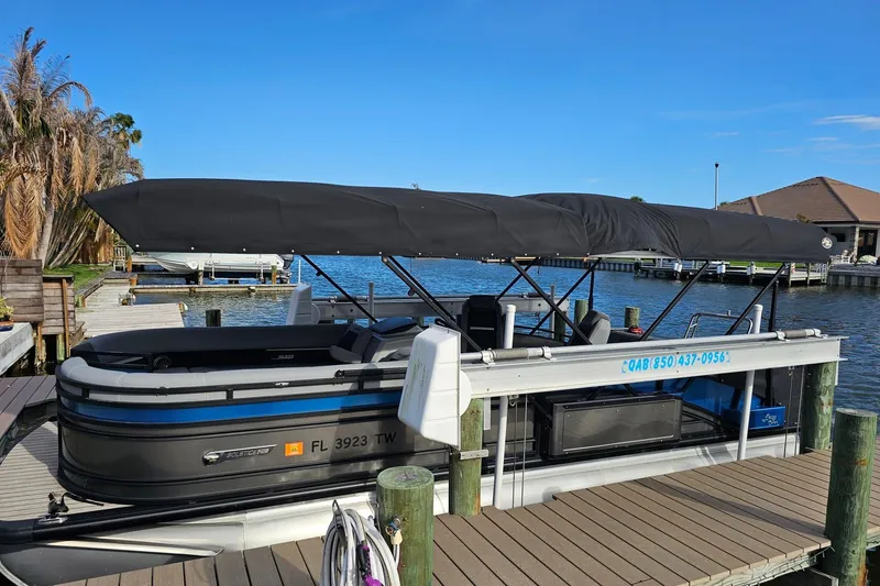 Slide: The Image of 2024 Harris pontoon boat docked by a serene waterfront. - 4