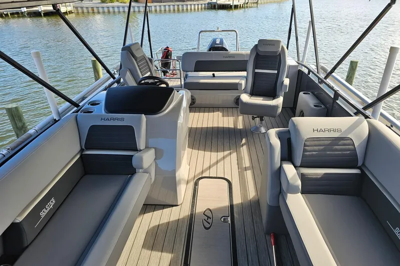 Slide: The Image of Luxurious 2024 Harris pontoon boat interior with plush seating and sleek design on the water. - 7
