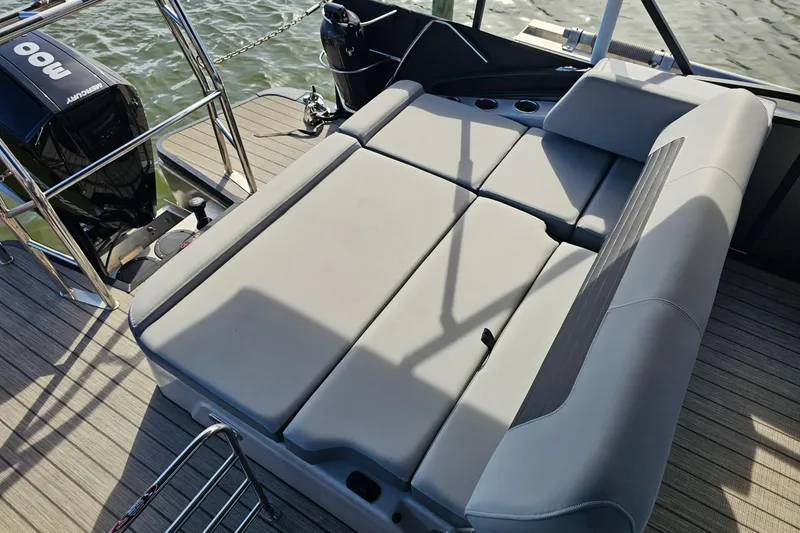 Slide: The Image of 2024 Harris boat with cushioned seating and Mercury outboard motor on deck. - 9