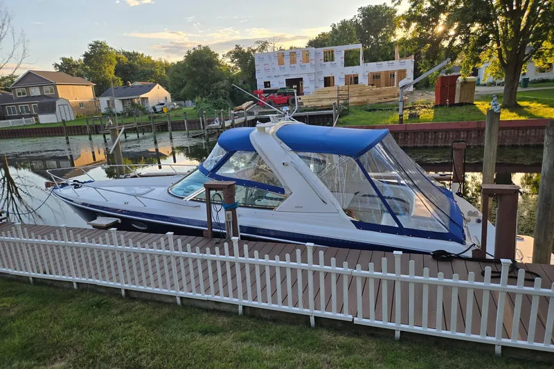 Slide: The Image of 2006 Formula 330 Sun Sport boat docked by a wooden fence, with a blue canopy. - 3