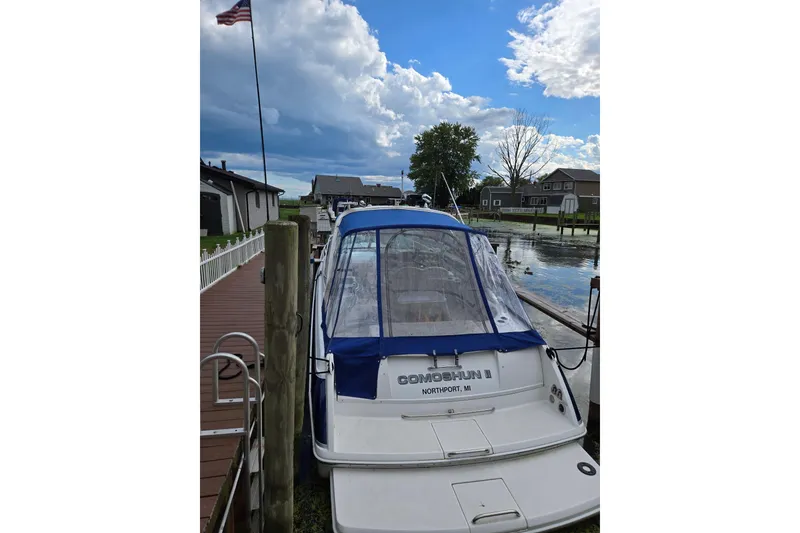 Slide: The Image of 2006 Formula 330 Sun Sport boat docked by a lakeside under a cloudy sky. - 5