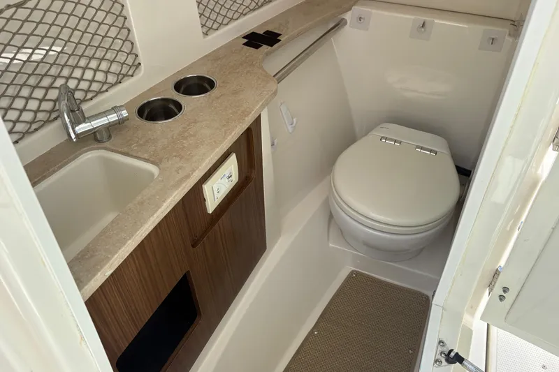 Slide: The Image of 2017 Sailfish 245 DC boat interior with sink, countertop, and marine toilet. - 12