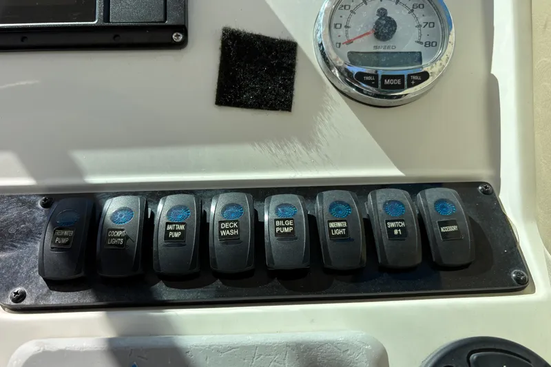 Slide: The Image of Control panel of a 2017 Sailfish 245 DC boat with labeled switches and speedometer. - 15