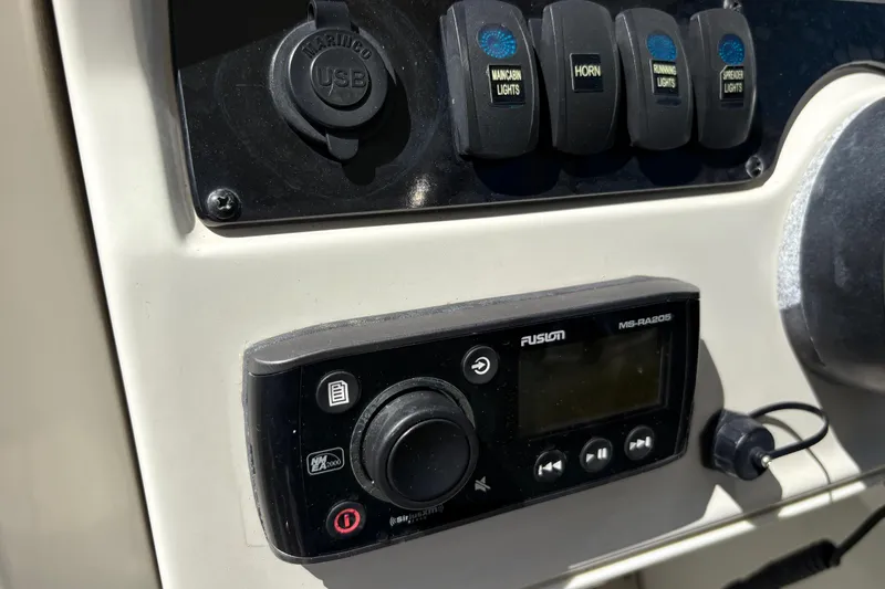 Slide: The Image of Control panel of a 2017 Sailfish 245 DC boat with USB port and audio system. - 18