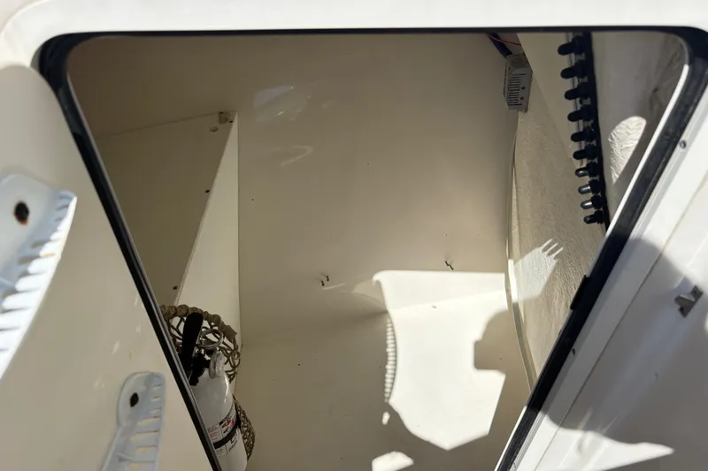 Slide: The Image of Storage compartment of a 2017 Sailfish 245 DC boat, featuring a fire extinguisher. - 19