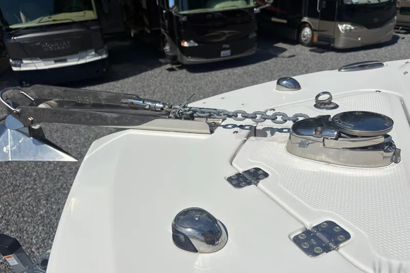 Slide: The Image of 2017 Sailfish 245 DC boat anchor and chain mechanism on deck, with RVs in background. - 23