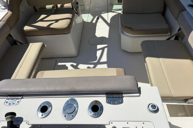Slide: The Image of 2017 Sailfish 245 DC boat interior with beige seating and fishing rod holders. - 5