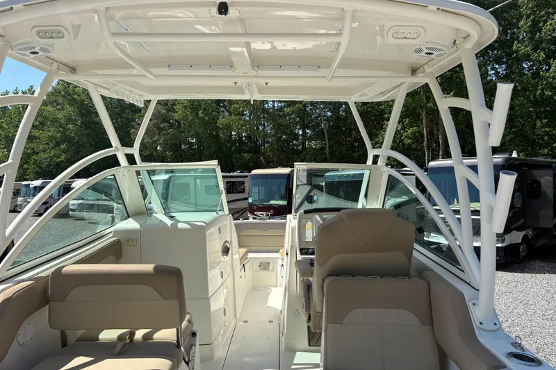 Slide: The Image of 2017 Sailfish 245 DC boat interior with seating and dashboard, parked outdoors. - 6