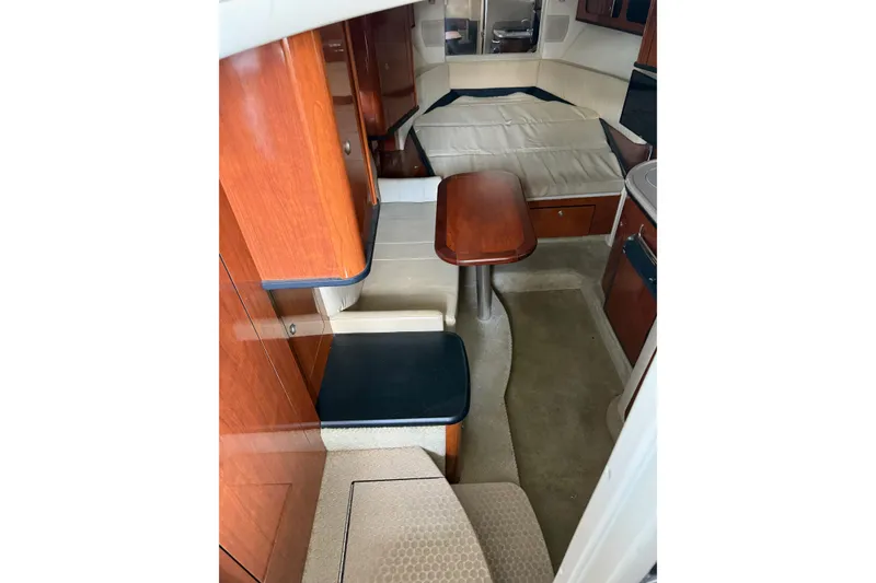 Slide: The Image of Interior of 2007 Sea Ray 290 Sundancer boat with wood cabinetry and seating area. - 13