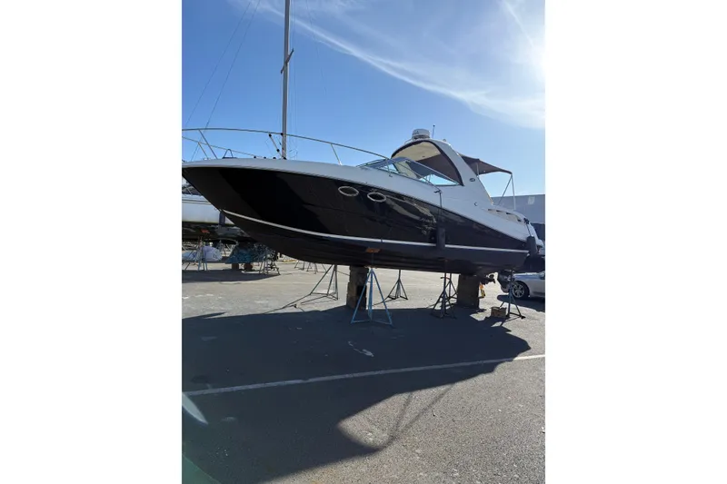 Slide: The Image of 2007 Sea Ray 290 Sundancer boat on stands in a sunny marina. - 4
