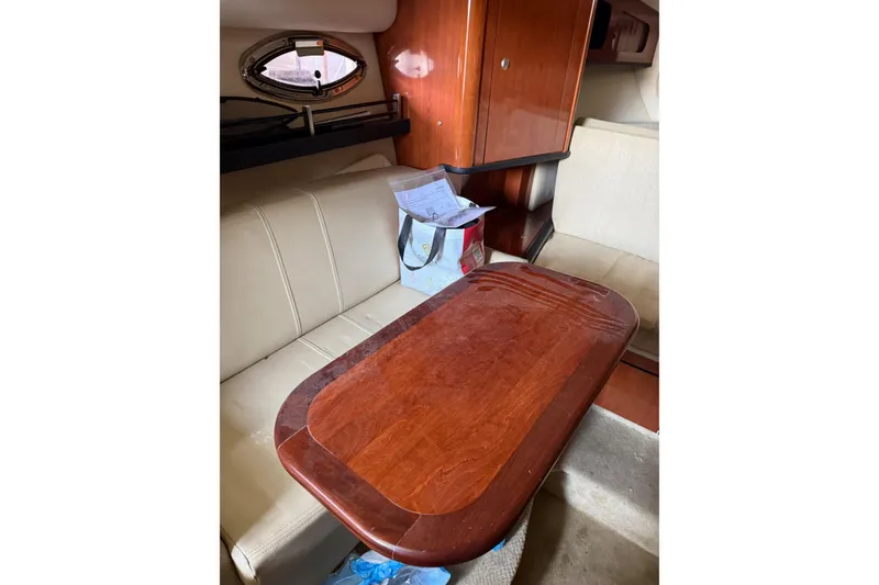 Slide: The Image of Interior of 2007 Sea Ray 290 Sundancer with wooden table and beige seating. - 9