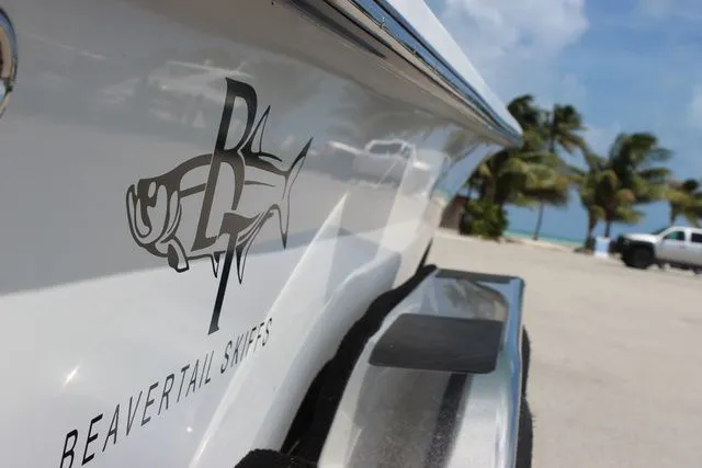 Slide: The Image of Beavertail Lightning 2019 boat at beach with palm trees. - 9