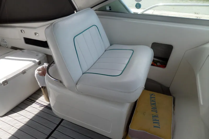 Slide: The Image of White seating area on 1994 Sea Ray 370 Express Cruiser with life jackets stored below. - 11
