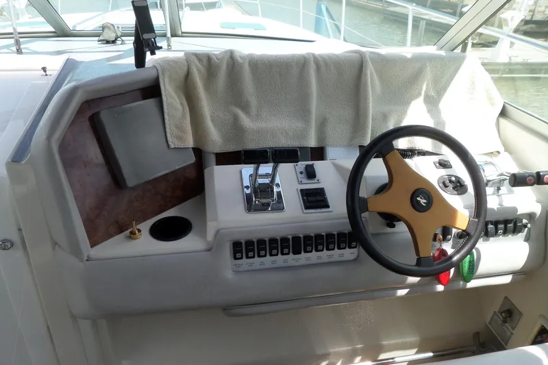 Slide: The Image of 1994 Sea Ray 370 Express Cruiser helm with steering wheel and control panel. - 14
