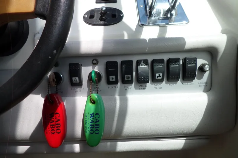 Slide: The Image of Control panel of a 1994 Sea Ray 370 Express Cruiser with keychains and switches. - 26