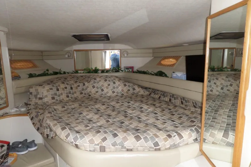 Slide: The Image of Interior cabin of 1994 Sea Ray 370 Express Cruiser with patterned bedding and mirror. - 28