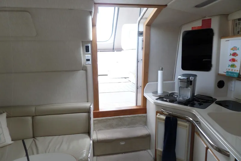 Slide: The Image of Interior of a 1994 Sea Ray 370 Express Cruiser with kitchenette and seating area. - 36