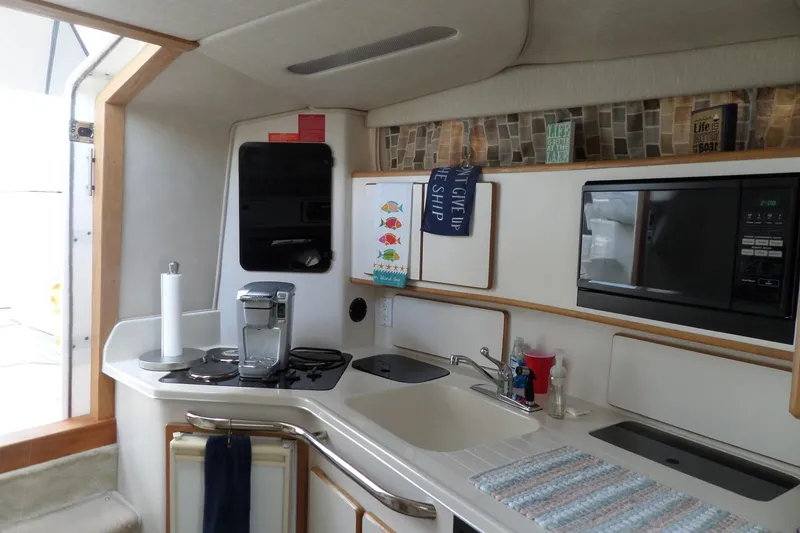 Slide: The Image of Interior of a 1994 Sea Ray 370 Express Cruiser kitchen with appliances and decor. - 37