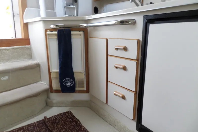 Slide: The Image of Interior of 1994 Sea Ray 370 Express Cruiser with steps, drawers, and kitchenette area. - 38