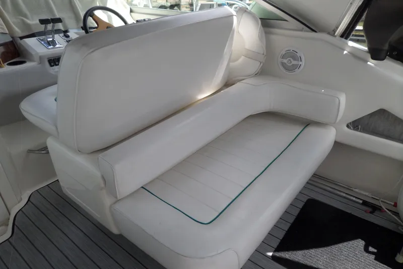 Slide: The Image of 1994 Sea Ray 370 Express Cruiser interior with white seating and steering controls. - 8