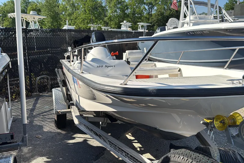 The Image of 2006 Boston Whaler 150 Sport boat on trailer, parked outdoors. - 1