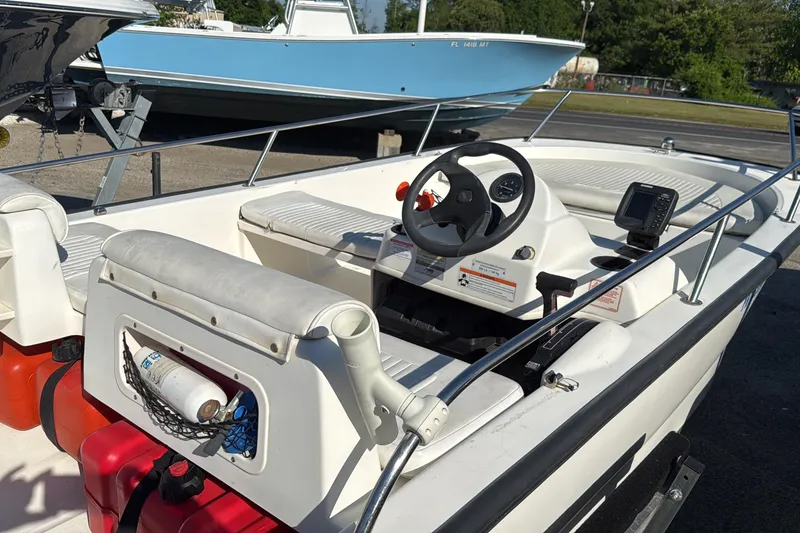 Slide: The Image of 2006 Boston Whaler 150 Sport boat interior with steering wheel and seating. - 3