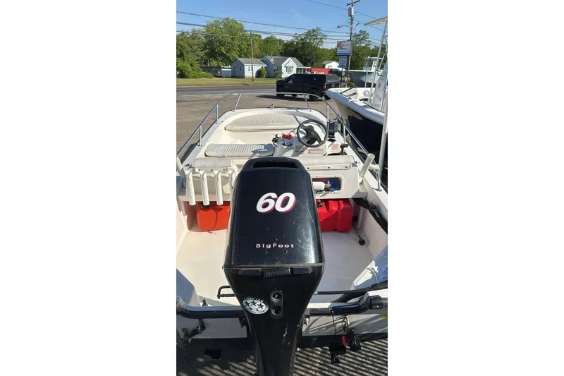 Slide: The Image of 2006 Boston Whaler 150 Sport boat with 60 HP BigFoot engine, docked outdoors. - 4