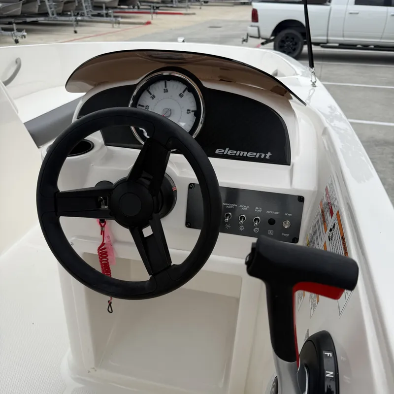 Slide: The Image of 2025 Bayliner E18LE boat dashboard with steering wheel and controls. - 18