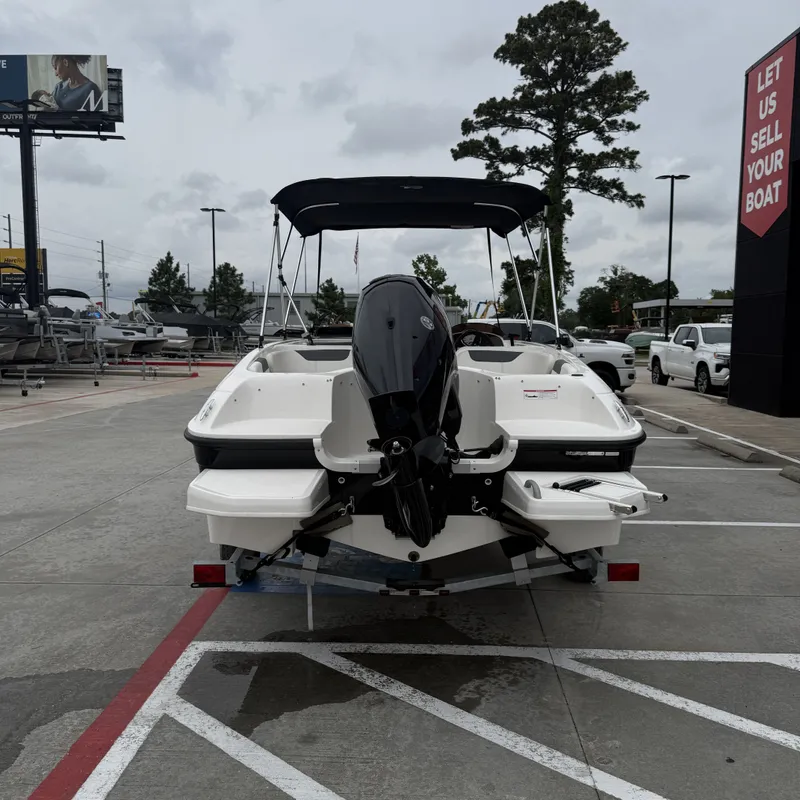 Slide: The Image of Rear view of a 2025 Bayliner E18LE boat in a parking lot. - 21