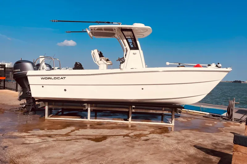 Slide: The Image of 2023 World Cat 235 CC boat on dock, featuring dual Yamaha engines, under clear blue sky. - 3