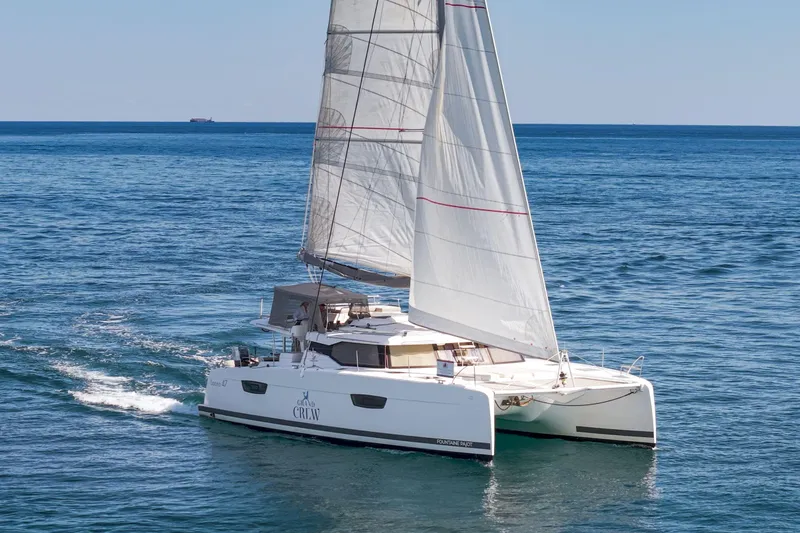 Slide: The Image of 2019 Fountaine Pajot 47 catamaran sailing on open sea with full sails. - 1