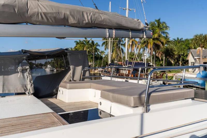 Slide: The Image of 2019 Fountaine Pajot 47 catamaran deck with sun loungers and tropical backdrop. - 10