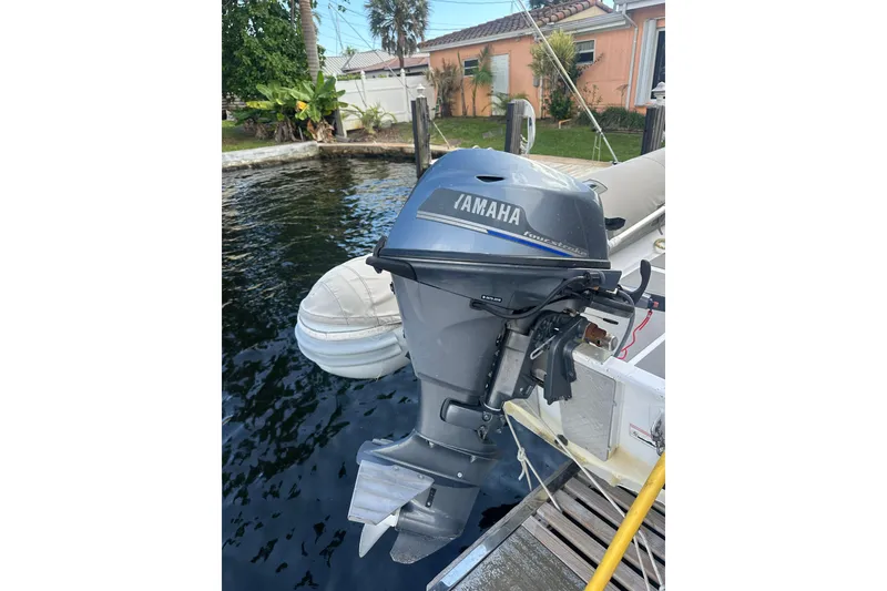 Slide: The Image of Yamaha outboard motor on a 2019 Fountaine Pajot 47 catamaran, docked by a waterfront home. - 82