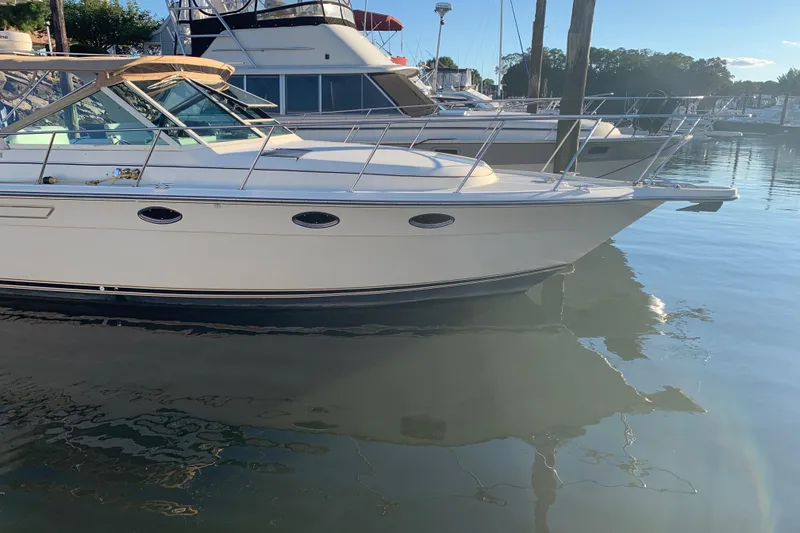 The Image of 1987 Tiara Yachts 3100 Open docked at a marina, reflecting on calm water. - 1