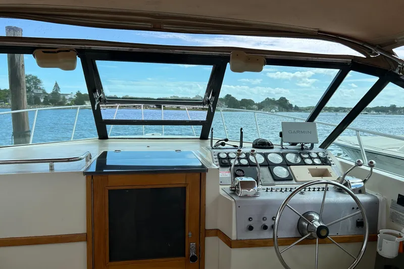 Slide: The Image of 1987 Tiara Yachts 3100 Open helm with Garmin navigation, overlooking serene waters. - 7