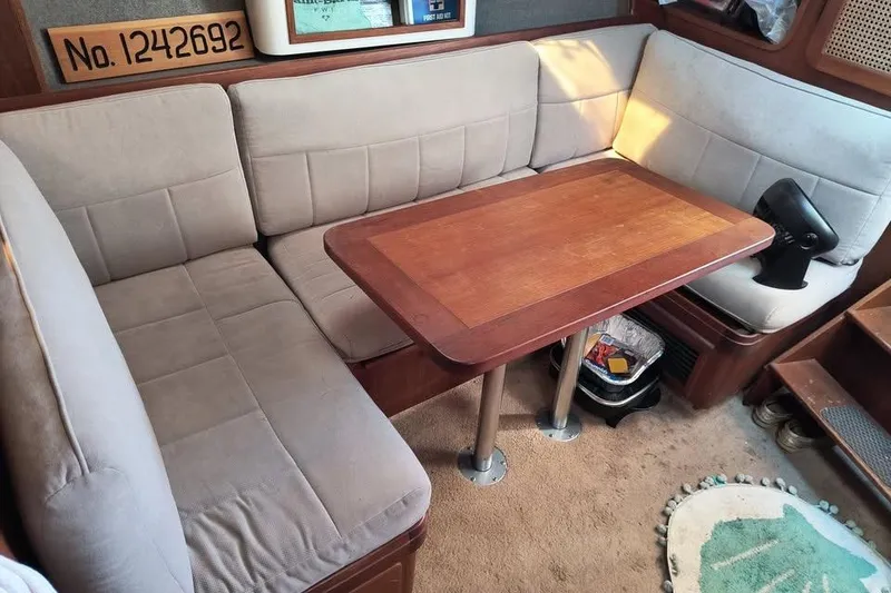 Slide: The Image of Interior of a 1987 Tiara Yachts 3100 Open with cushioned seating and wooden table. - 9