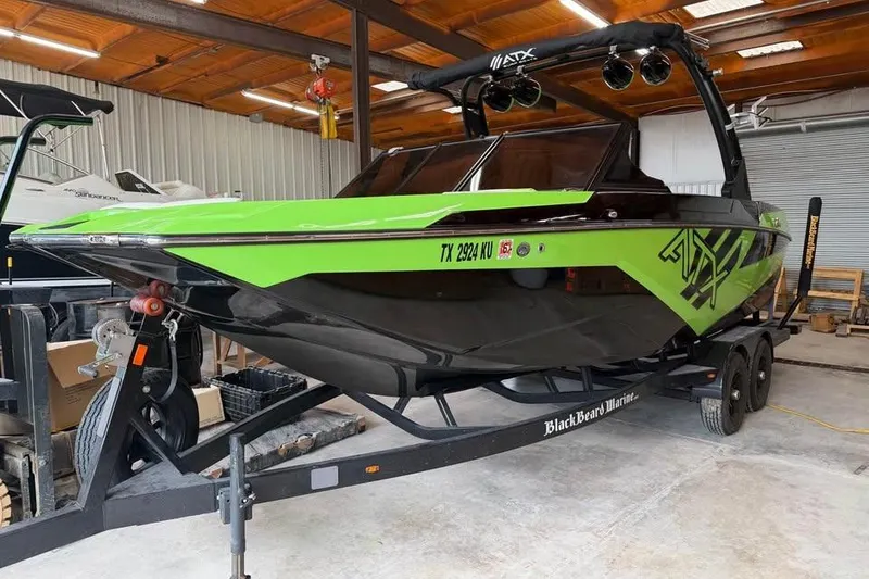 Slide: The Image of 2022 ATX Surf Boats 24 Type-S in a garage, vibrant green and black design. - 1