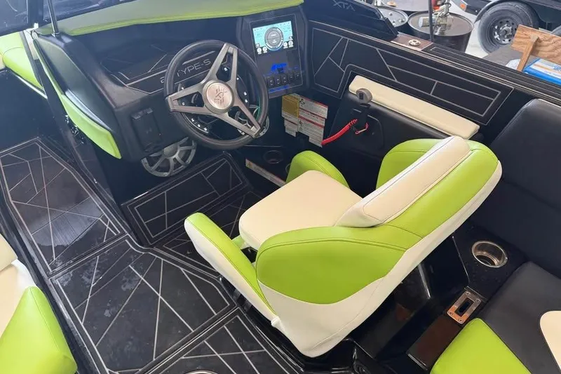 Slide: The Image of 2022 ATX Surf Boats 24 Type-S interior with green and white seating, modern dashboard. - 10