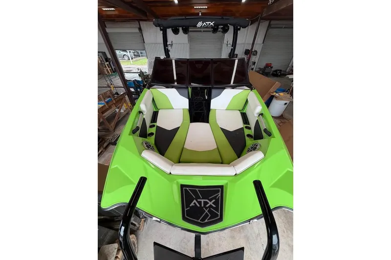 Slide: The Image of 2022 ATX Surf Boats 24 Type-S with vibrant green and white interior in a garage setting. - 11
