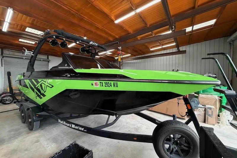 Slide: The Image of 2022 ATX Surf Boats 24 Type-S in a garage, vibrant green and black design. - 2