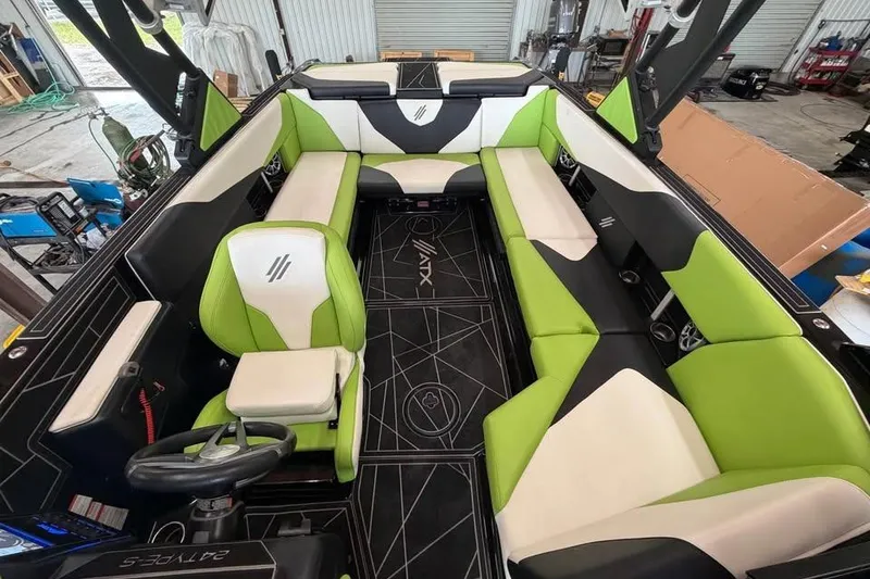 Slide: The Image of 2022 ATX Surf Boats 24 Type-S interior with green and white seating in a workshop. - 6