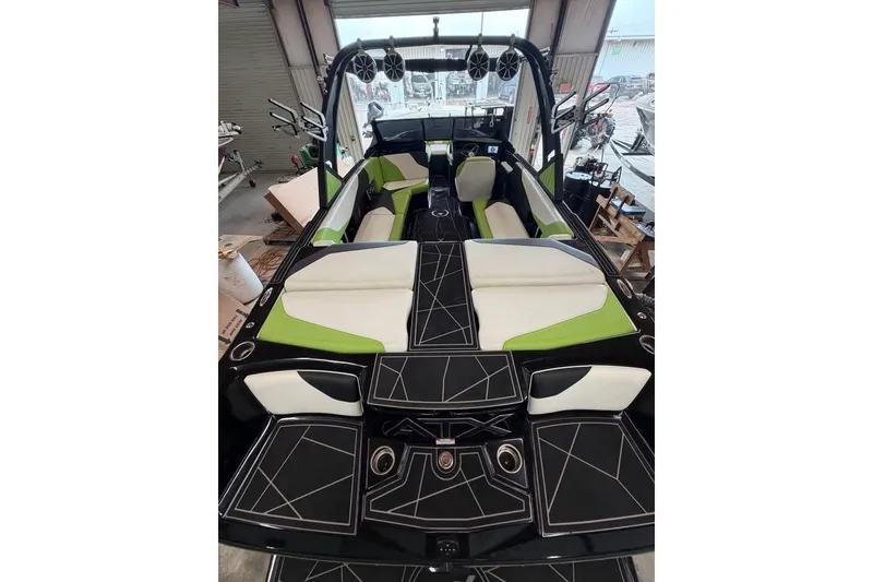 Slide: The Image of 2022 ATX Surf Boats 24 Type-S interior with green and white seating, black geometric flooring. - 7
