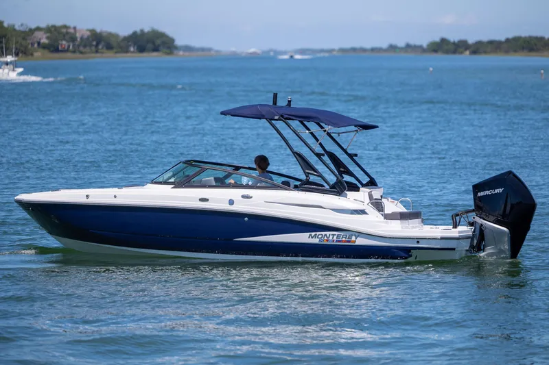 Slide: The Image of 2024 Monterey M-45 boat cruising on a serene blue lake with a Mercury engine. - 1