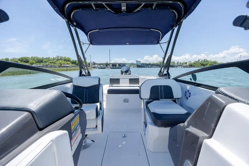 Slide: The Image of 2024 Monterey M-45 boat interior with seating, steering wheel, and canopy on a sunny day. - 15
