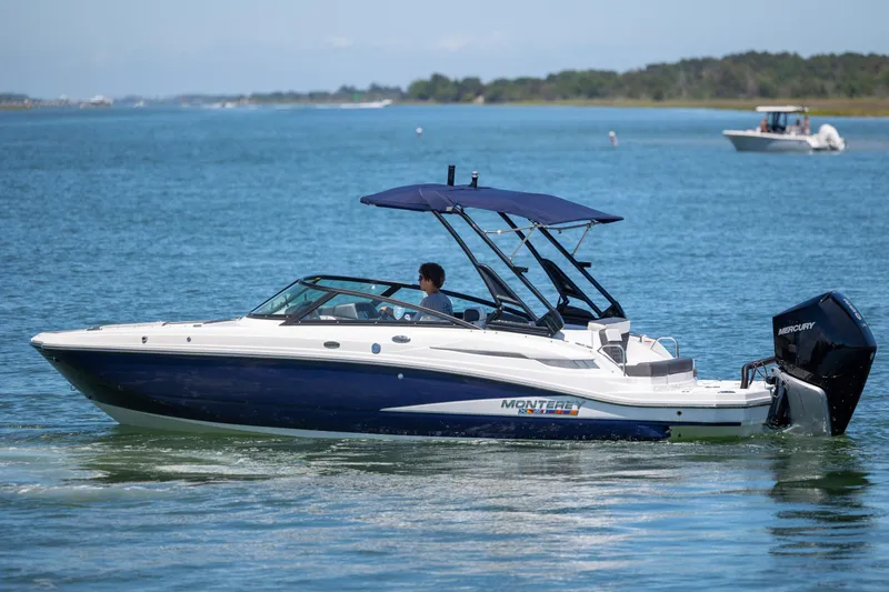 Slide: The Image of 2024 Monterey M-45 boat cruising on a sunny lake with a Mercury engine. - 2